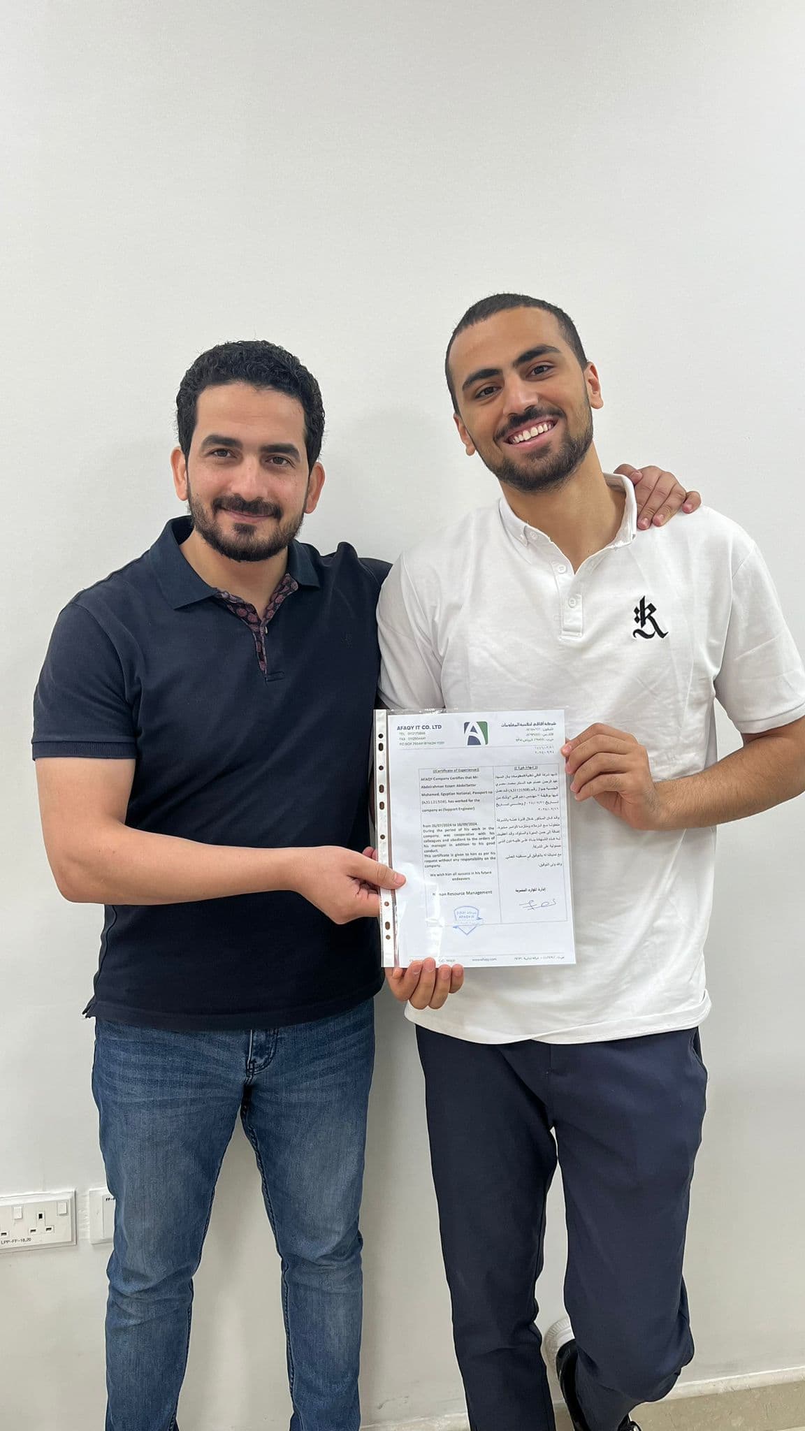 Abdelrahman receiving the AFAQY experience certificate with a team member in Riyadh